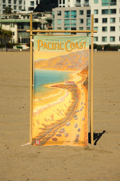 Pacific Coast vintage travel poster beach towel hanging on a rack at the beach